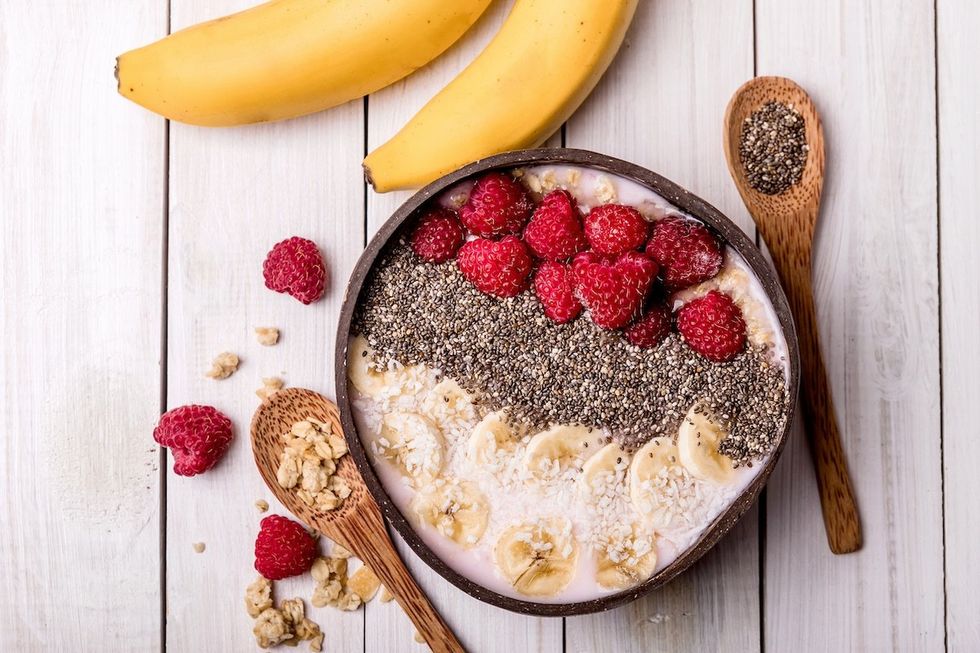 a bowl of yogurt with bananas, raspberries, and chia seeds